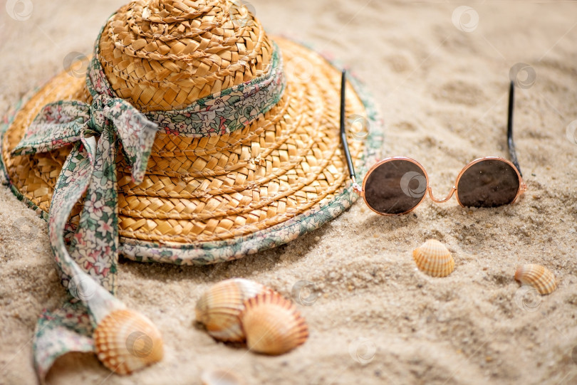Скачать Соломенная шляпа и солнцезащитные очки, оставленные на песчаном пляже во время летних каникул фотосток Ozero