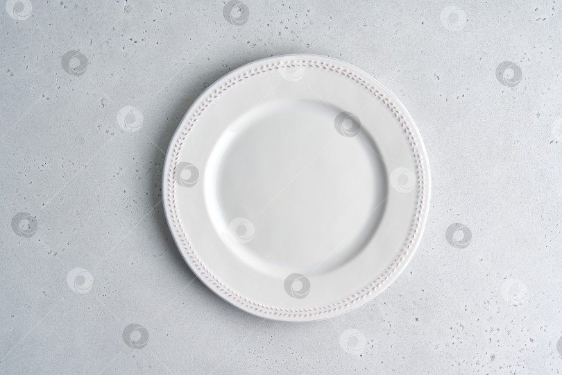 Скачать Пустая белая керамическая тарелка на светлом фоне. Место для копирования, вид сверху, горизонтально, крупным планом фотосток Ozero