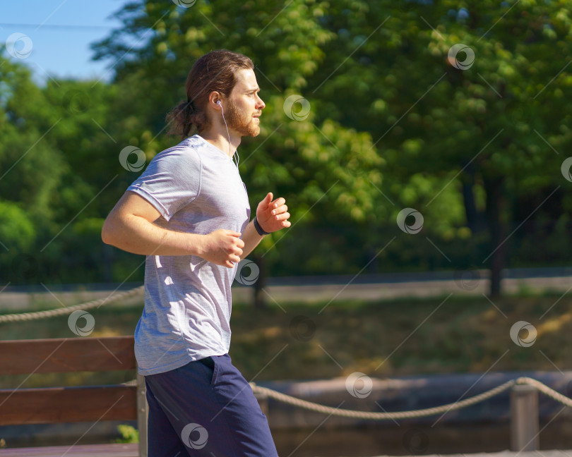 Скачать Спортивный мужчина в спортивной одежде, бегущий в парке летним днем фотосток Ozero