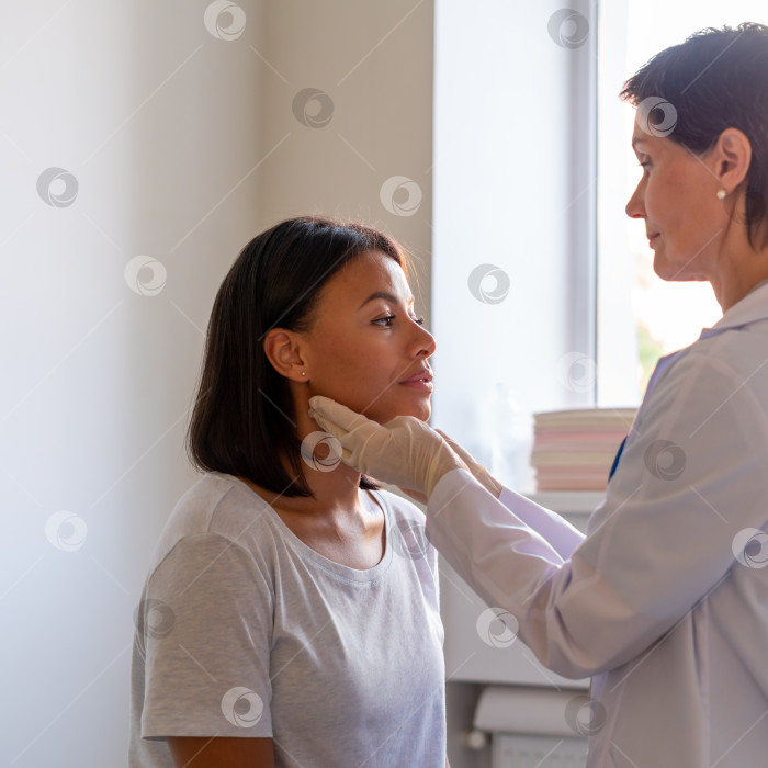 Скачать Ларинголог осматривает горло пациентки, посещающей врача в больнице фотосток Ozero