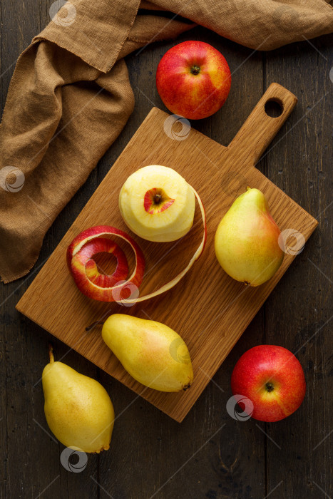 Скачать Очищенные красные яблоки и груши на деревянной разделочной доске. Вертикальный пищевой фон фотосток Ozero