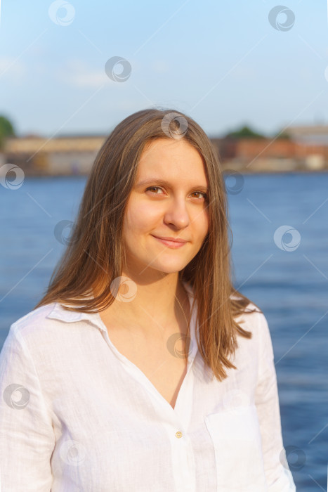 Скачать Портрет жизнерадостной молодой девушки, стоящей у реки на городской набережной и наслаждающейся летом фотосток Ozero