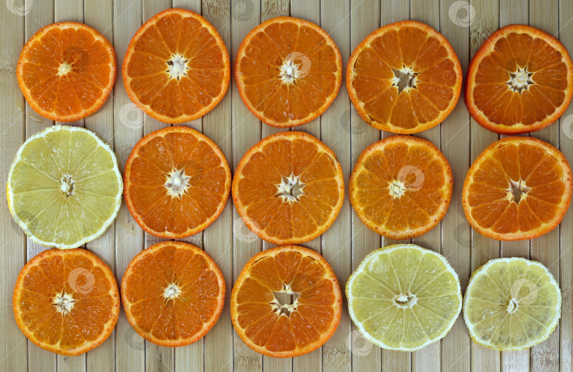 Скачать фон с цитрусовыми ломтиками лимона и мандарина на выровненной деревянной поверхности фотосток Ozero
