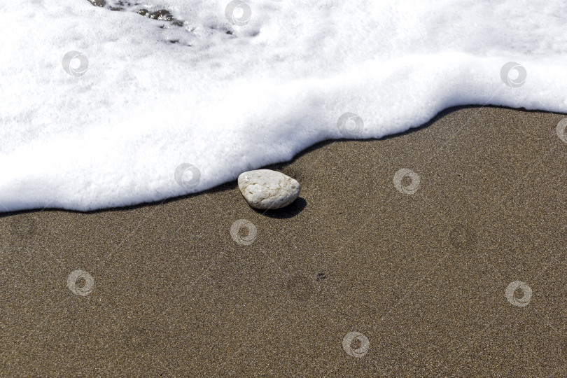 Скачать Одинокий камень на песке в полосе прибоя. фотосток Ozero