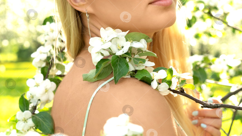 Скачать Цветущая ветка яблони лежит на плече обнаженной женщины в весеннем саду фотосток Ozero