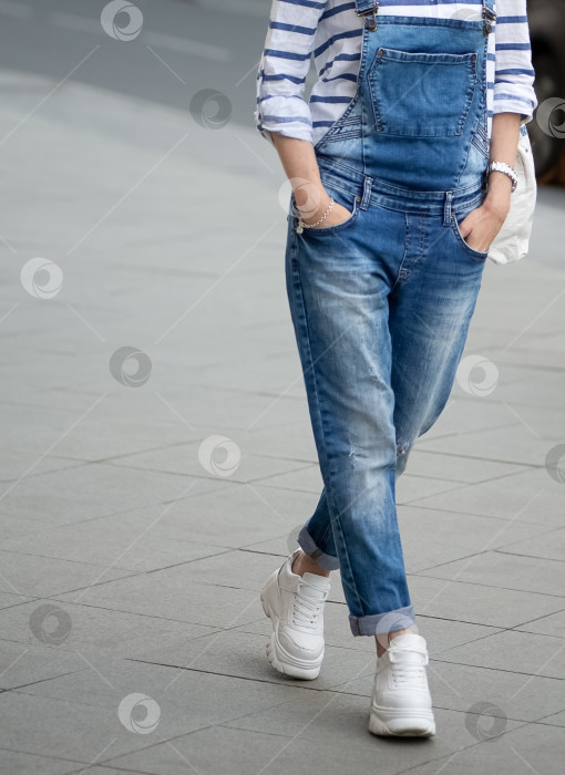 Скачать женщина в синих джинсах идет по улице фотосток Ozero