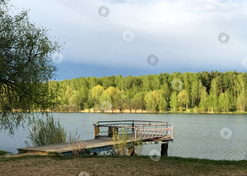 Скачать Старый деревянный пирс над озерной водой с лесом на горизонте фотосток Ozero