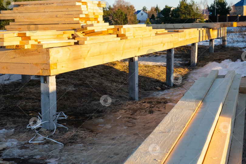 Скачать Фундамент деревянного каркасного дома на сваях - это строительная площадка, процесс возведения каркаса фотосток Ozero