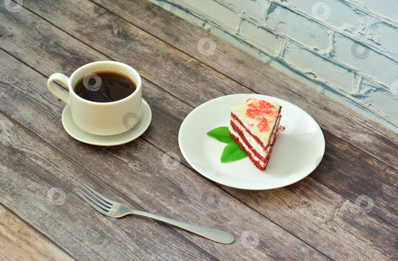 Скачать Тарелка с куском торта "красный бархат" с листьями мяты и чашкой горячего черного кофе на деревянном столе. фотосток Ozero