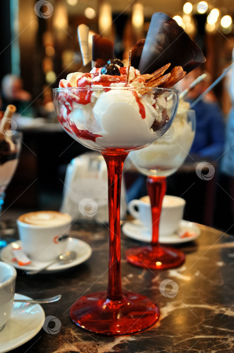 Скачать вкусное мороженое в стеклянной вазочке на столе в кафе фотосток Ozero