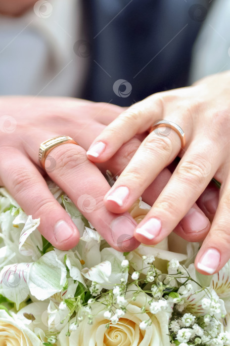 Скачать жених и невеста держатся за руки с обручальными кольцами на букете фотосток Ozero