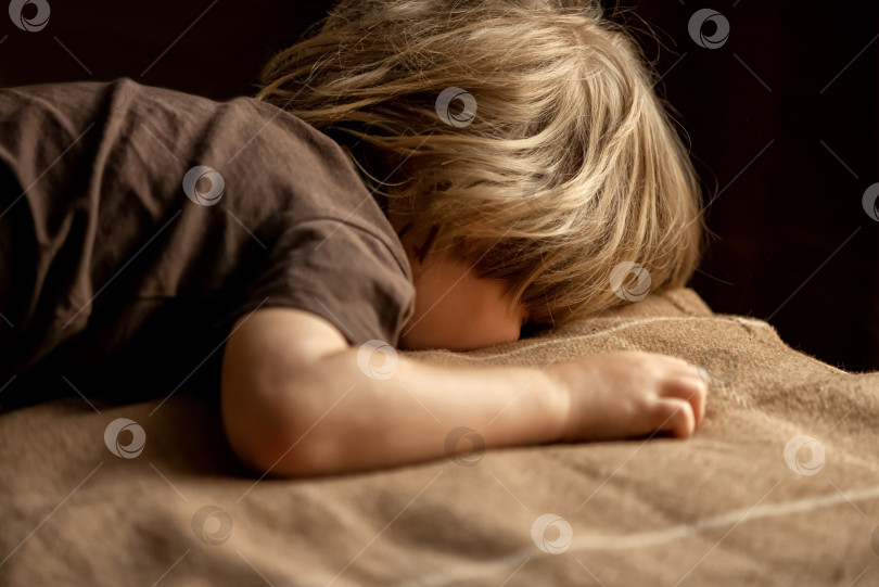 Скачать ребенок лежит на кровати лицом вниз фотосток Ozero
