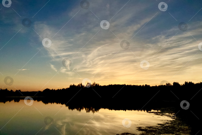 Скачать Волшебный августовский летний закат на лесном озере с солнечным светом, отражающимся на поверхности воды фотосток Ozero