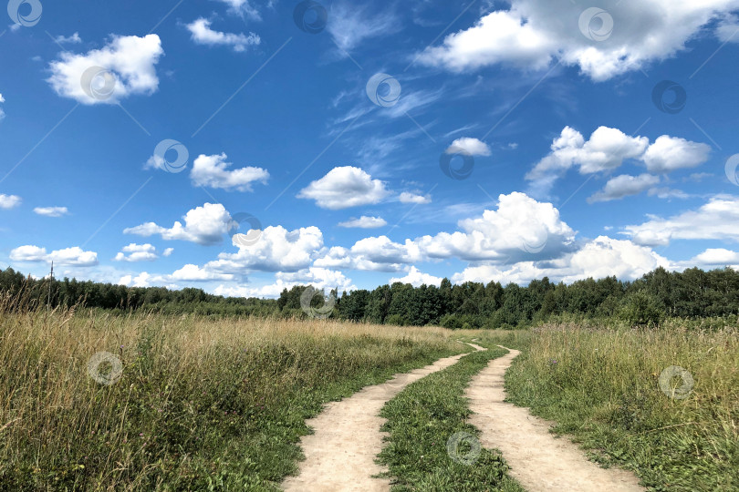 Скачать Извилистая проселочная дорога под голубым облачным небом фотосток Ozero