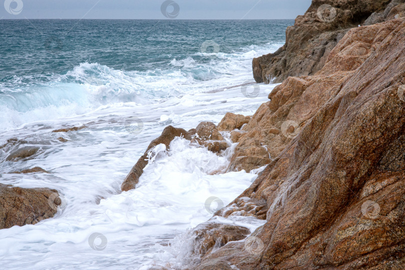 Скачать Пенящиеся морские волны разбиваются о прибрежные скалы. Морской природный ландшафт фотосток Ozero