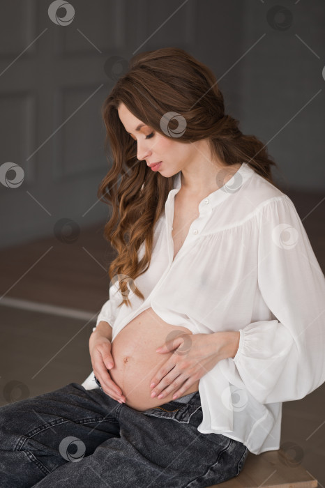 Скачать Беременная девушка гладит свой большой живот в фотостудии 4063. фотосток Ozero