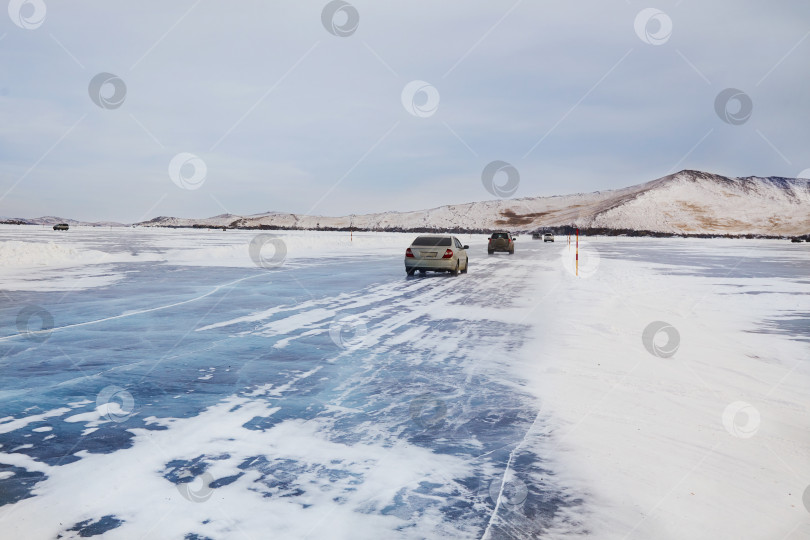 Скачать Зимние путешествия, машины едут по льду. Ледяная дорога по замерзшему озеру Байкал фотосток Ozero