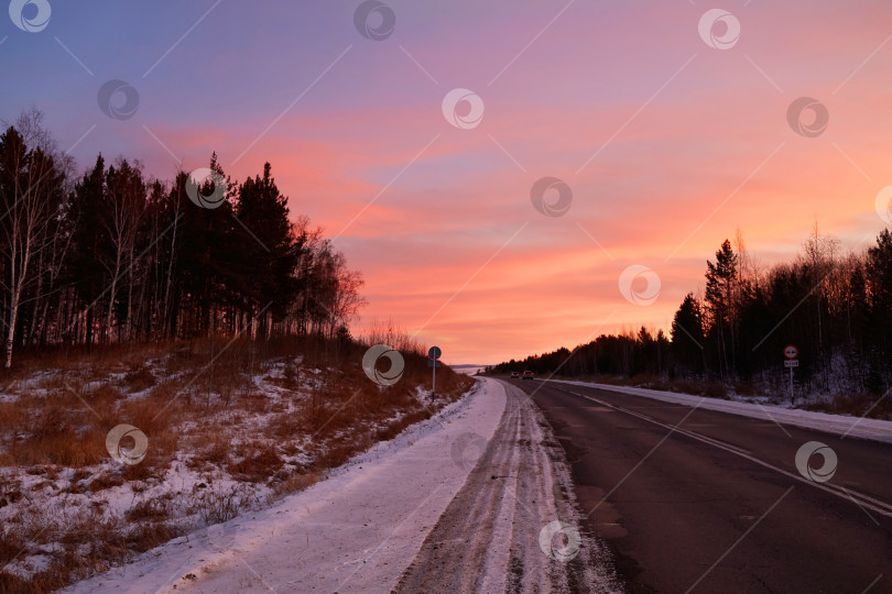 Скачать Яркий красочный рассвет зимой. Асфальтированная дорога за городом фотосток Ozero