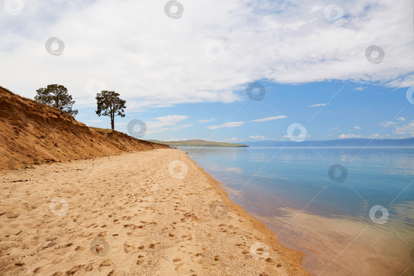 Скачать Берег озера Байкал в пасмурный летний день. Спокойная голубая вода, песчаный пляж. Красивый летний пейзаж. фотосток Ozero