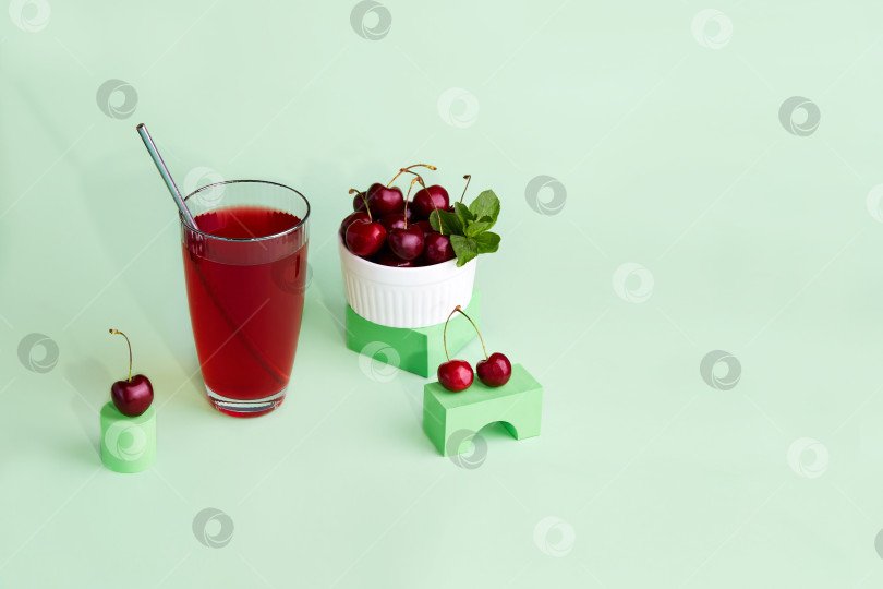 Скачать Бокал вишневого коктейля, вазочка с ягодой. Свежий холодный освежающий летний напиток с вишней и льдом. фотосток Ozero