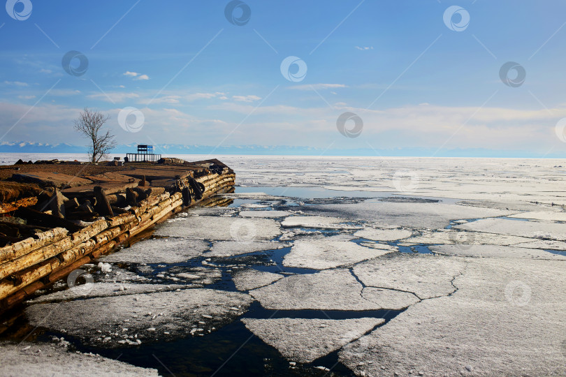 Скачать Старый деревянный пирс. Льдины и открытая вода. Озеро Байкал весной. фотосток Ozero