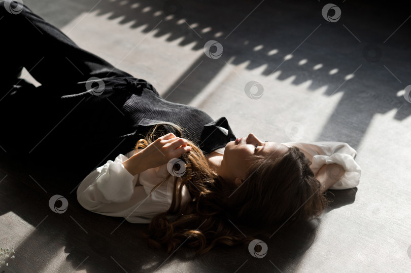 Скачать Красивая девушка с распущенными волосами лежит на полу 4110. фотосток Ozero