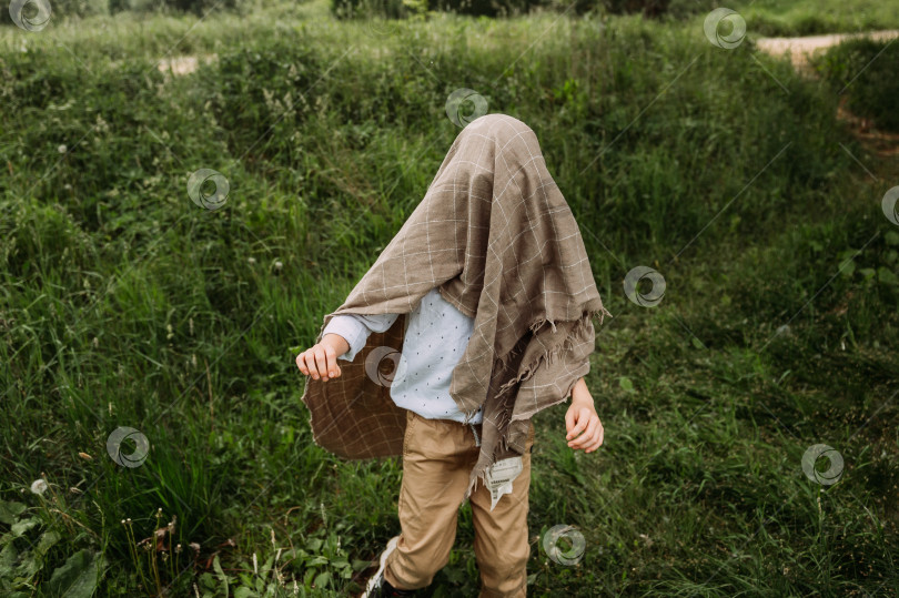 Скачать Ребенок положил сумку на оползень и играет в призрака 4150. фотосток Ozero