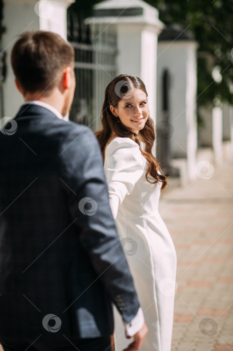 Скачать Мужчина и женщина держатся за руки. На женщине свадебное платье, а на мужчине костюм. 5116 фотосток Ozero