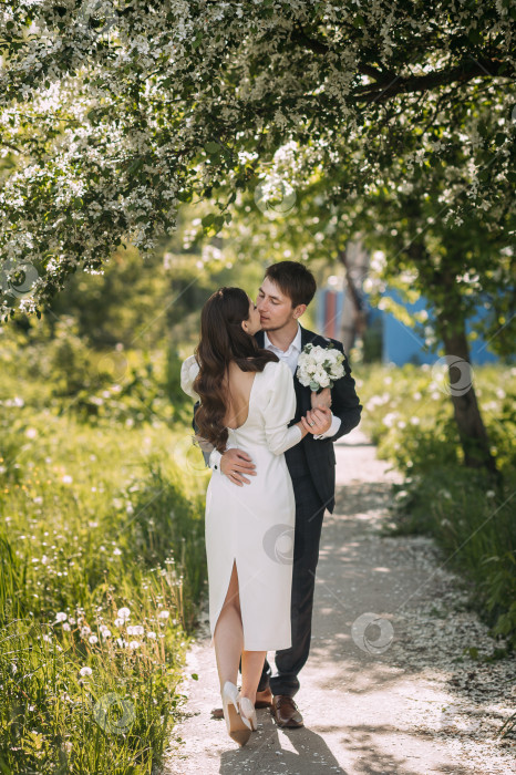 Скачать Мужчина и женщина целуются на дорожке в саду. На ней изображен романтический момент между парой. 5179 фотосток Ozero