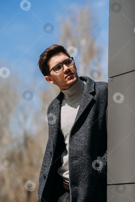 Скачать Мужчина, стоящий на улице, в солнцезащитных очках, черной куртке и сером пальто фотосток Ozero