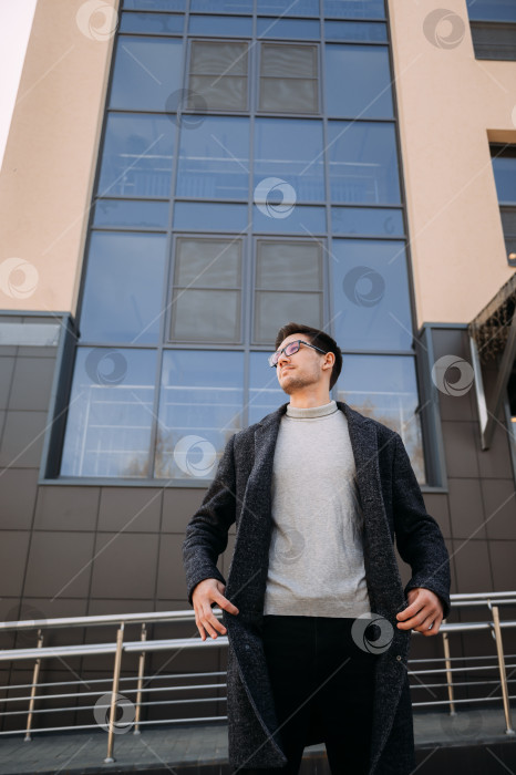 Скачать Человек, стоящий перед зданием с большим окном. 4728 фотосток Ozero