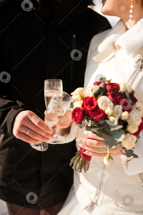 Скачать Бокалы с шампанским в руках молодоженов на зимней свадьбе 4132. фотосток Ozero