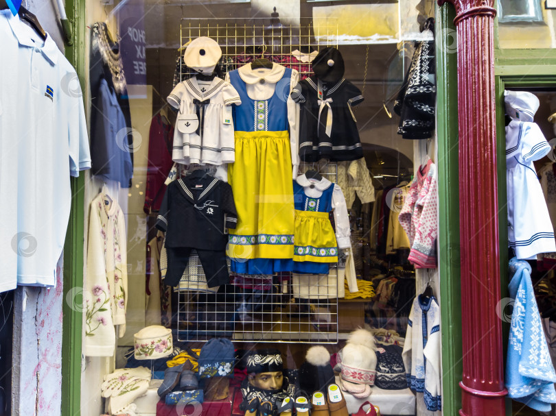 Скачать Витрина с детской одеждой в традиционном шведском стиле и национальной цветовой гамме на главной торговой улице Стокгольма, Швеция фотосток Ozero
