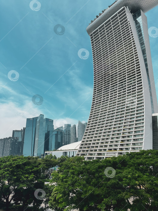 Скачать Строительная симфония: Изогнутый силуэт Marina Bay Sands на фоне небоскребов Сингапура фотосток Ozero