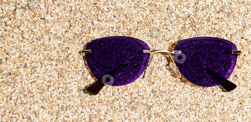Скачать Солнцезащитные очки лежат на песке на пляже фотосток Ozero