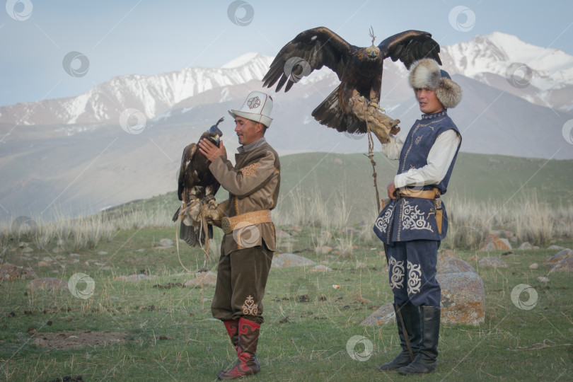 Скачать Молодой киргиз держит на руке расправленные крылья орла фотосток Ozero