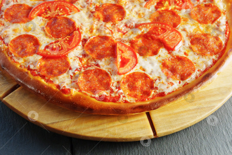 Скачать Восхитительная пицца с пепперони и помидорами на деревянной доске фотосток Ozero