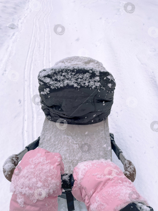 Скачать Отец, идущий впереди во время безмятежной зимней прогулки, укрытый свежевыпавшим снегом. Вертикальное фото фотосток Ozero