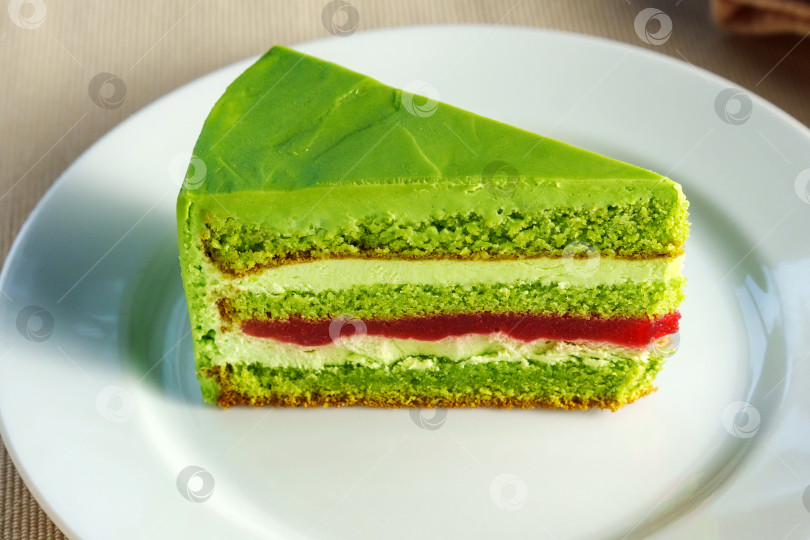 Скачать Демонстрирующий восхитительный кусочек зеленого торта на нетронутой белой тарелке, соблазняющий зрителя фотосток Ozero
