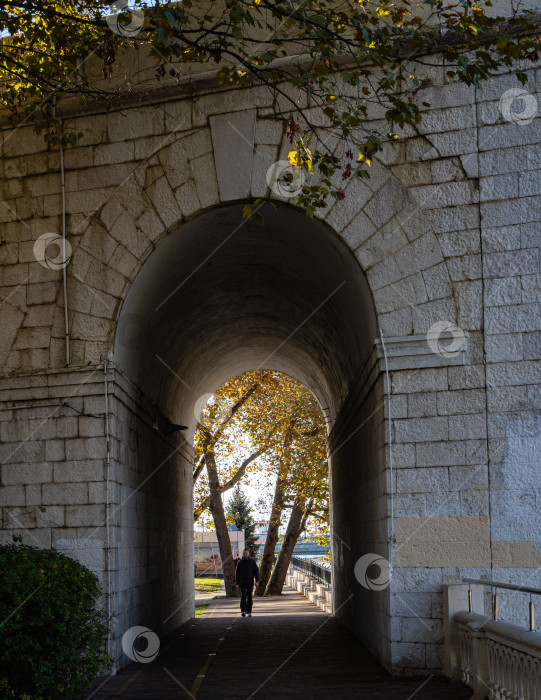 Скачать Центр Сочи. Золотая осень. Вид на старый каменный автомобильный мост. Набережная реки Сочи. Пешеходная дорожка вдоль набережной. фотосток Ozero