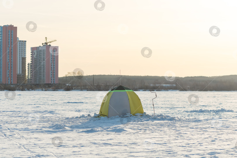 Скачать Подледная рыбалка. Палатка и рыболовный шнек, ледяной шнек на заснеженном озере зимой, зимнее времяпрепровождение, хобби, отдых фотосток Ozero