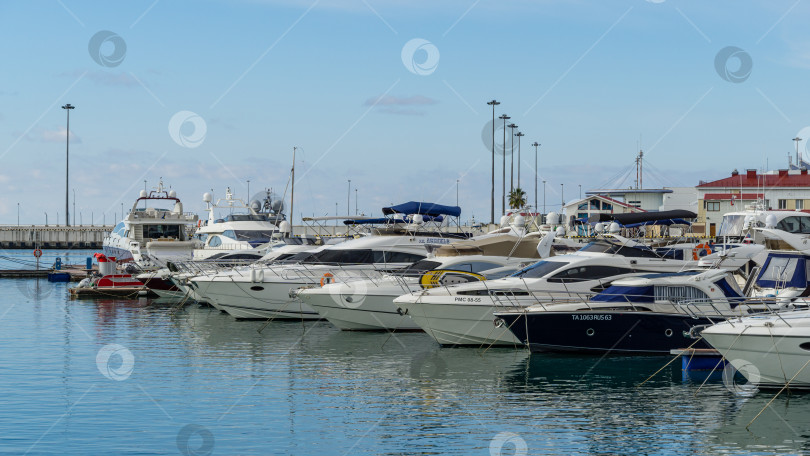 Скачать Корабли, яхты и катера на голубой глади Черного моря у причала Морского торгового порта Сочи. Центр города-курорта. Сочи, Россия - 23 ноября 2020 г. фотосток Ozero