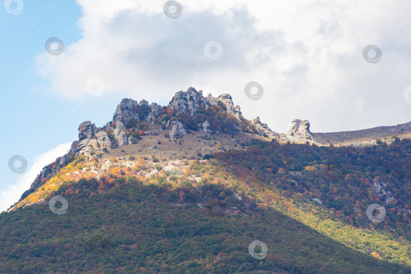 Скачать Живописные осенние склоны Крымских гор на южном побережье Крыма. Место Долина призраков на горе Демерджи. Знаменитая гора Демерджи с облаками на фоне голубого неба. фотосток Ozero