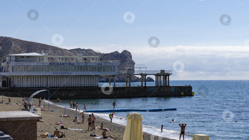 Скачать Живописный крымский пейзаж с голубой водой Черного моря на фоне гор. Туристическая достопримечательность города-курорта Судак. Судак, Крым, Россия – 2 октября 2019 г. фотосток Ozero