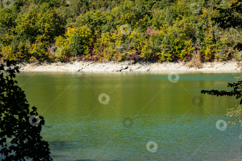 Скачать Изумрудная вода озера в Сукко на фоне горы, покрытой лесами. Природная красота курорта недалеко от Анапы. фотосток Ozero