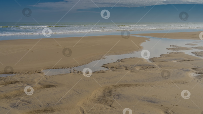 Скачать Отлив в океане. На песке видны лужицы и ручейки воды фотосток Ozero