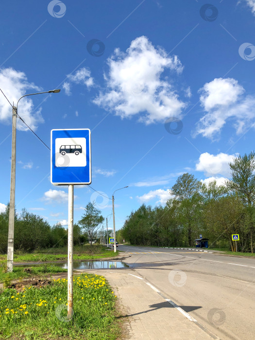 Скачать Дорожный знак автобусной остановки на фоне голубого неба у края дороги фотосток Ozero