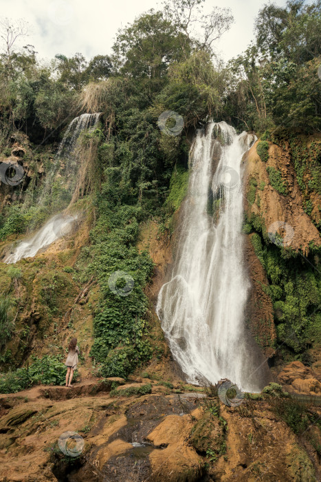 Скачать Водопад в тропическом лесу и женщина, смотрящая на него фотосток Ozero