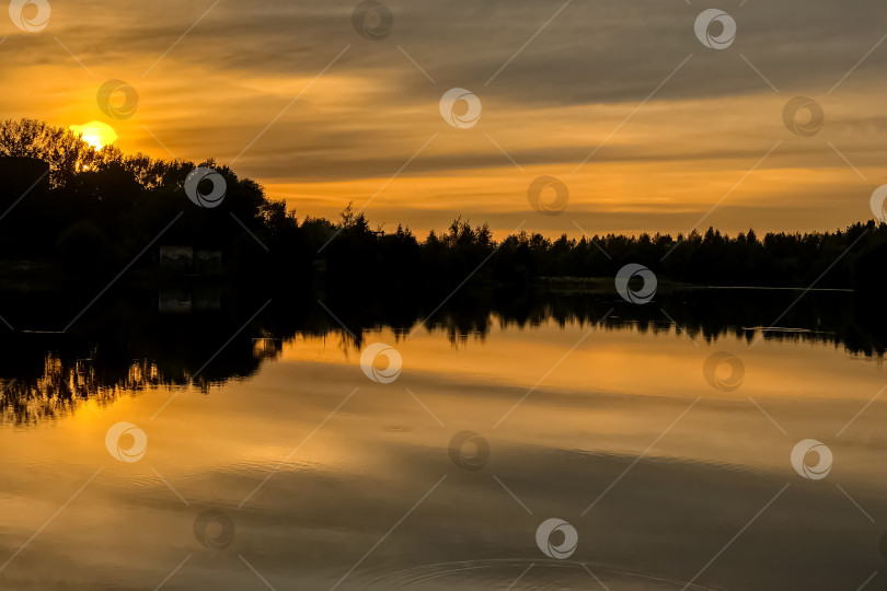 Скачать Летний закат на лесном озере с оранжевым небом, отражающимся в воде фотосток Ozero