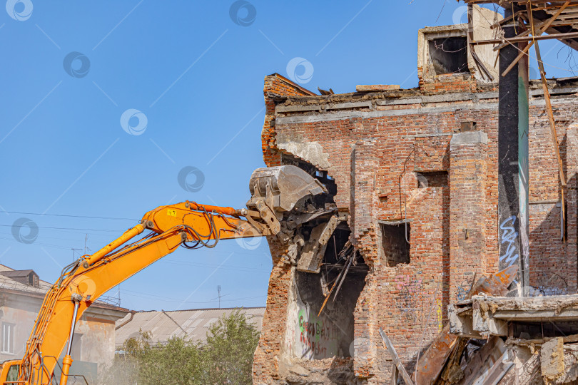 Скачать Специальный экскаватор разрушает кирпичную стену старого здания фотосток Ozero